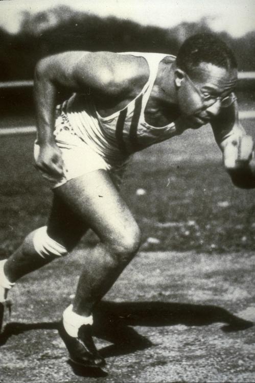 Edie Tolan in mid-sprint wearing white uniform.